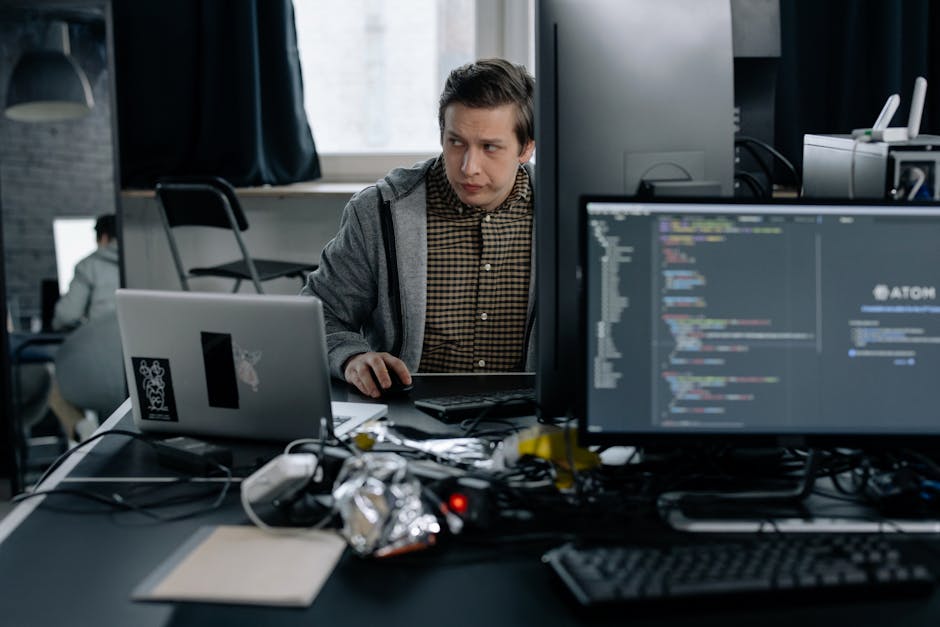 A programmer in a modern office working on computer code, showcasing a focused work environment