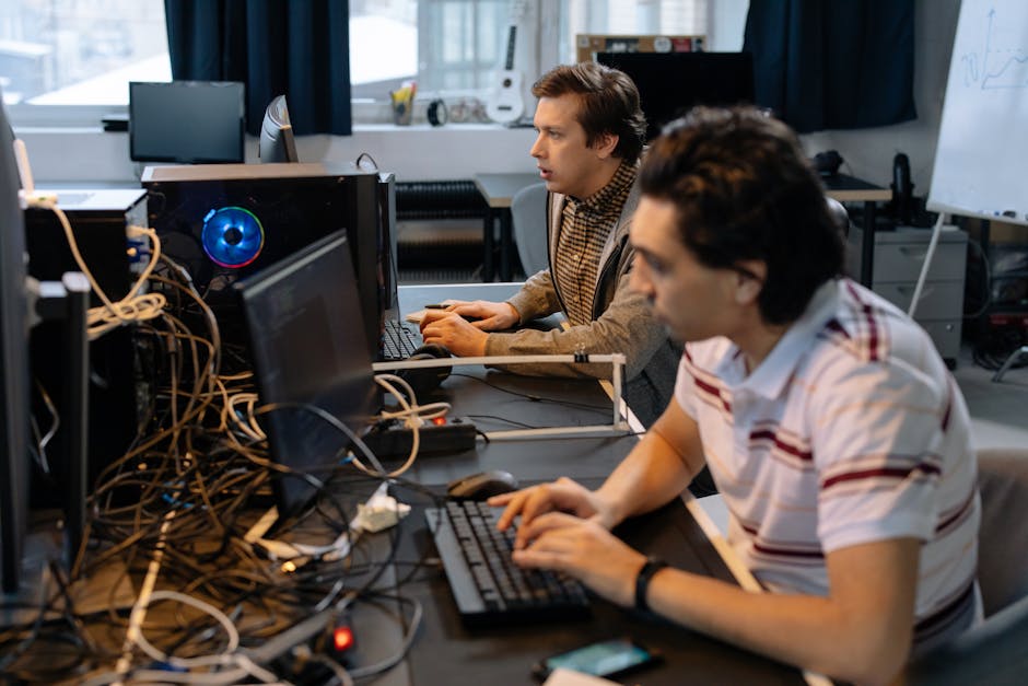 Male programmers working on computers in a modern office setting, showcasing teamwork and technology